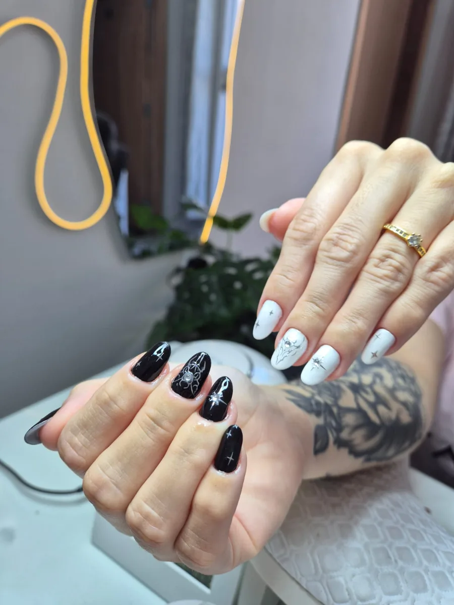 Unhas alongadas em preto e branco com detalhes prateados, depois do alongamento